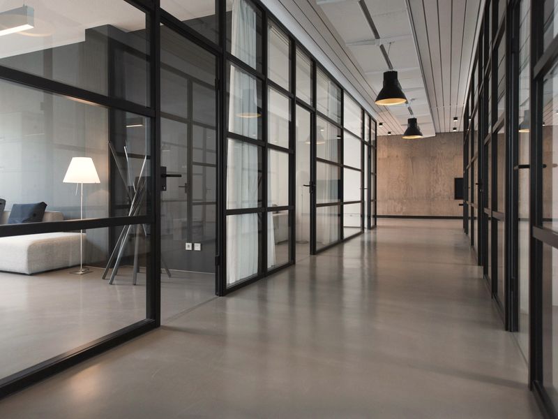 Pasillo de oficinas separadas por muros de vidrio